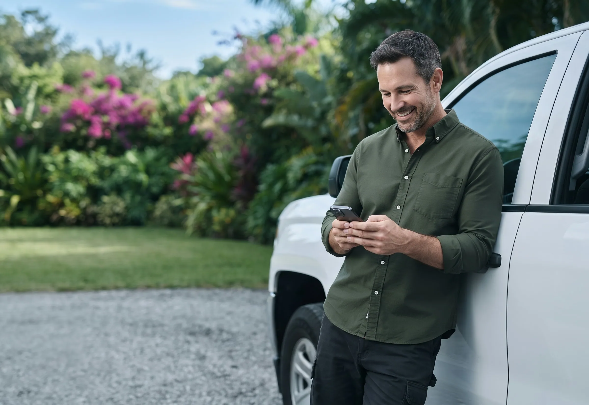A landscaping business owner reading his monthly Care report between jobs